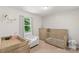 Bedroom featuring light wood furniture, including a crib, dresser, and changing table at 2012 Killarney Pl, Charlotte, NC 28262
