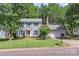 Charming two-story home with light gray siding, blue shutters, manicured lawn and mature trees at 2012 Killarney Pl, Charlotte, NC 28262
