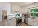 Open concept kitchen with white cabinetry, stainless steel appliances, and granite countertops at 2012 Killarney Pl, Charlotte, NC 28262