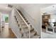 Carpeted staircase with white railings leads to the upper level, providing an elegant transition at 2012 Killarney Pl, Charlotte, NC 28262