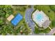This aerial view captures a community pool, tennis court, and parking area surrounded by trees at 2026 Rosewater Ln, Indian Trail, NC 28079