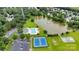 This aerial view captures a community pool, tennis court, pond, and parking area surrounded by trees at 2026 Rosewater Ln, Indian Trail, NC 28079