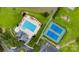 This aerial view captures a community pool and tennis court surrounded by trees and green grass at 2026 Rosewater Ln, Indian Trail, NC 28079
