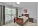 Cozy bedroom with a wood-framed bed, blackout curtains, and light parquet flooring at 2026 Rosewater Ln, Indian Trail, NC 28079