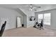 This bonus room features a full-length mirror, ceiling fan, modern television, and video game set up at 2026 Rosewater Ln, Indian Trail, NC 28079