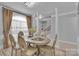 Elegant dining room with seating for six, large windows, and decorative pillars at 2026 Rosewater Ln, Indian Trail, NC 28079