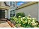 Close-up of the front entrance with colorful flowers, green bushes, and brick accents, creating an inviting entry at 2026 Rosewater Ln, Indian Trail, NC 28079