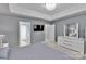 Main bedroom offering a tray ceiling, ceiling fan, and an ensuite bathroom with double doors at 2026 Rosewater Ln, Indian Trail, NC 28079
