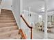 Carpeted staircase with wood railing leading to the second floor, adjacent to the dining room at 2026 Rosewater Ln, Indian Trail, NC 28079