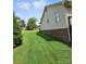 Spacious backyard featuring lush lawn and partial view of home's exterior at 217 Rock Creek Dr, Lincolnton, NC 28092