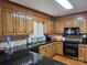 Well-equipped kitchen with wood cabinetry, black appliances, and granite countertops at 217 Rock Creek Dr, Lincolnton, NC 28092