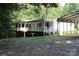 White raised home with a wrap-around porch, two-car garage and lush lawn at 220 Singing Pine Dr, Clover, SC 29710