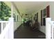 Long covered porch featuring rocking chairs, windows, and dark wooden floors at 220 Singing Pine Dr, Clover, SC 29710