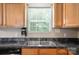 Kitchen sink with wood cabinets, stone counters, and stainless steel dishwasher at 2239 Blue Hampton Ln, Charlotte, NC 28213