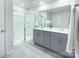 Bathroom with double sink, gray cabinets, shower and a large mirror at 240 Orson Oaks Ln, Pineville, NC 28134