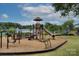 Well-equipped community playground with a variety of slides and play structures, all set against a picturesque lake at 240 Orson Oaks Ln, Pineville, NC 28134