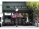 The Brass Bird exterior showing classic architecture, floral displays, and inviting storefront seating at 240 Orson Oaks Ln, Pineville, NC 28134