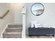 Carpeted stairs with a decorative gray storage bench and a round mirror on the wall at 240 Orson Oaks Ln, Pineville, NC 28134