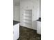 Bright kitchen with custom white cabinetry, sleek countertops, open shelving, and modern flooring at 29 Willow St # 31, Badin, NC 28009