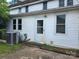 Exterior rear view of the home, highlighting the back door, multiple windows, and a central air conditioning unit at 29 Willow St, Badin, NC 28009