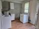 A laundry room featuring a washing machine, dryer, cabinets, shelving, and a window for natural light at 29 Willow St, Badin, NC 28009