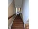 Wooden staircase leading down to a white door at the bottom, providing a view of the lower level at 29 Willow St, Badin, NC 28009