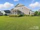 Well-maintained backyard with a large lawn, shrubs, and a screened-in porch on the home at 3007 Arsdale Rd, Waxhaw, NC 28173