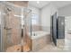 Modern bathroom featuring a glass shower, soaking tub, and neutral tile at 3007 Arsdale Rd, Waxhaw, NC 28173