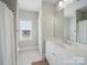 Bright bathroom with white cabinets, neutral walls, and a walk-in shower behind a curtain at 3007 Arsdale Rd, Waxhaw, NC 28173