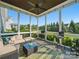 Cozy screened porch featuring a ceiling fan, a sofa, stools, and an outdoor view at 3007 Arsdale Rd, Waxhaw, NC 28173