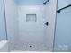Modern bathroom showcasing a stylish, tiled walk-in shower with sleek black fixtures at 305 E Henry St, Belmont, NC 28012