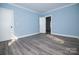 Spacious bedroom features sleek plank flooring, light blue walls, and open doorways at 305 E Henry St, Belmont, NC 28012