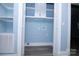 A spacious laundry room is painted in light blue with white trim, built-in shelves and gray wood-look flooring at 305 E Henry St, Belmont, NC 28012
