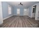 Bright living room with grey wood floors, modern ceiling fan and adjacent bathroom at 305 E Henry St, Belmont, NC 28012