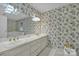 Bathroom features a dual sink vanity, floral wallpaper, and a soaking tub at 327 Saint Andrews Rd, Statesville, NC 28625