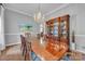 Formal dining room with a long table, elegant chandelier, and a custom cabinet for displaying fine china at 327 Saint Andrews Rd, Statesville, NC 28625