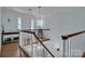 Inviting hallway featuring hardwood floors, elegant lighting, and staircase with white spindles and stained banister at 327 Saint Andrews Rd, Statesville, NC 28625