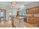 Sunlit kitchen featuring an island with sink, tile flooring, and wood cabinets at 327 Saint Andrews Rd, Statesville, NC 28625