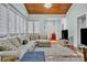 Cozy living room with wood-paneled ceiling, comfortable sectional sofa, and abundant natural light at 327 Saint Andrews Rd, Statesville, NC 28625