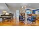 Open concept living room with a fireplace, grand piano, hardwood floors and blue accent chairs at 327 Saint Andrews Rd, Statesville, NC 28625