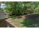 View of a grassy backyard with mature trees and shade; small outbuilding included at 3724 Patricia Nw Dr, Concord, NC 28027