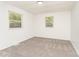 This bedroom features neutral carpet, white walls, and two windows for ample natural light at 3724 Patricia Nw Dr, Concord, NC 28027