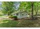 Side view of the house showing the lush landscaping and surrounding greenery at 3724 Patricia Nw Dr, Concord, NC 28027