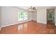 Bright living room featuring hardwood floors, a ceiling fan, and a large window at 3729 Woodleaf Rd, Charlotte, NC 28205