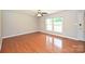 Bright living room with hardwood floors, ceiling fan, and large windows at 3729 Woodleaf Rd, Charlotte, NC 28205