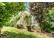 Landscaped front yard with mature trees and foundation plantings providing shade and curb appeal at 5238 Downing Creek Dr, Charlotte, NC 28269
