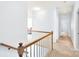 Second floor hallway with wood railing, carpeted floor and three visible doors at 5238 Downing Creek Dr, Charlotte, NC 28269