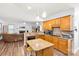 Open kitchen overlooking living area with stainless steel appliances, wood cabinets, and island at 5238 Downing Creek Dr, Charlotte, NC 28269