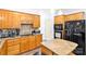 Traditional kitchen with wood cabinets, granite countertops and black appliances at 5238 Downing Creek Dr, Charlotte, NC 28269