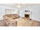 Cozy living room featuring a fireplace, plush sofa, and ample natural light at 5238 Downing Creek Dr, Charlotte, NC 28269